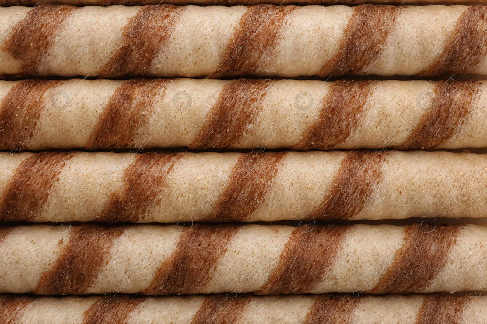 Photo of Tasty wafer roll sticks as background, top view. Crispy food