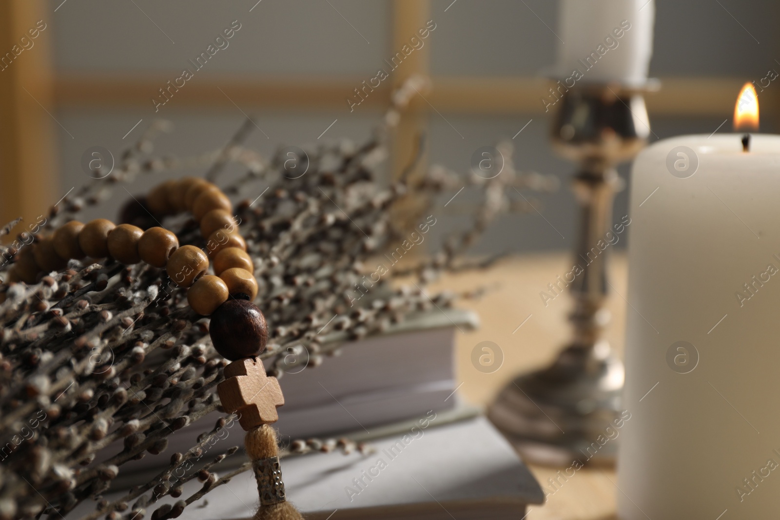 Photo of Rosary beads and willow branches on table, closeup. Space for text