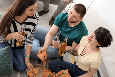 Young people having fun party with delicious pizza indoors