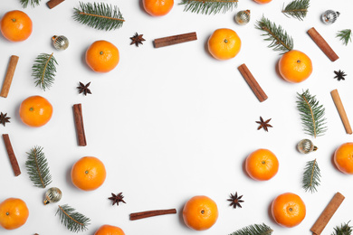 Flat lay composition with ripe tangerines, fir branches, cinnamon and Christmas decor on white background. Space for text
