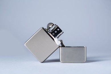 Metallic cigarette lighter on light gray background, closeup