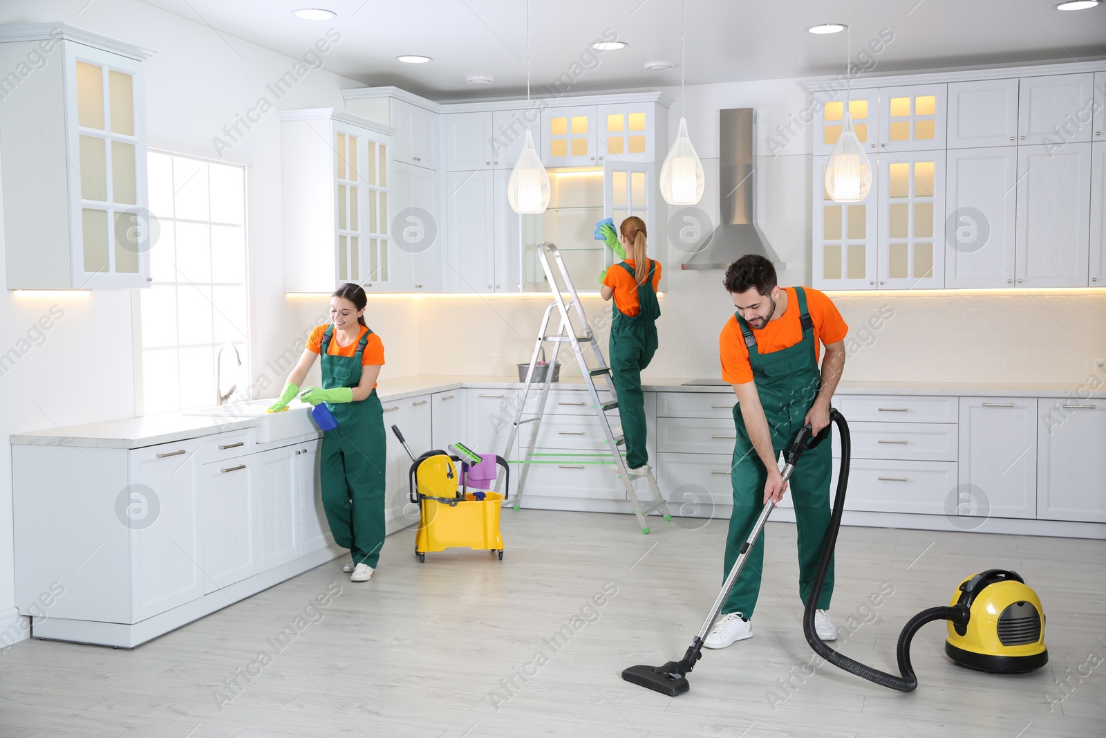 Photo of Team of professional janitors cleaning modern kitchen