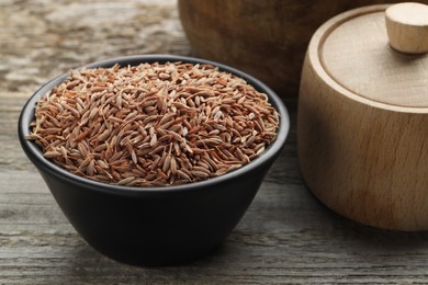 Photo of Bowl of caraway seeds on wooden table, closeup