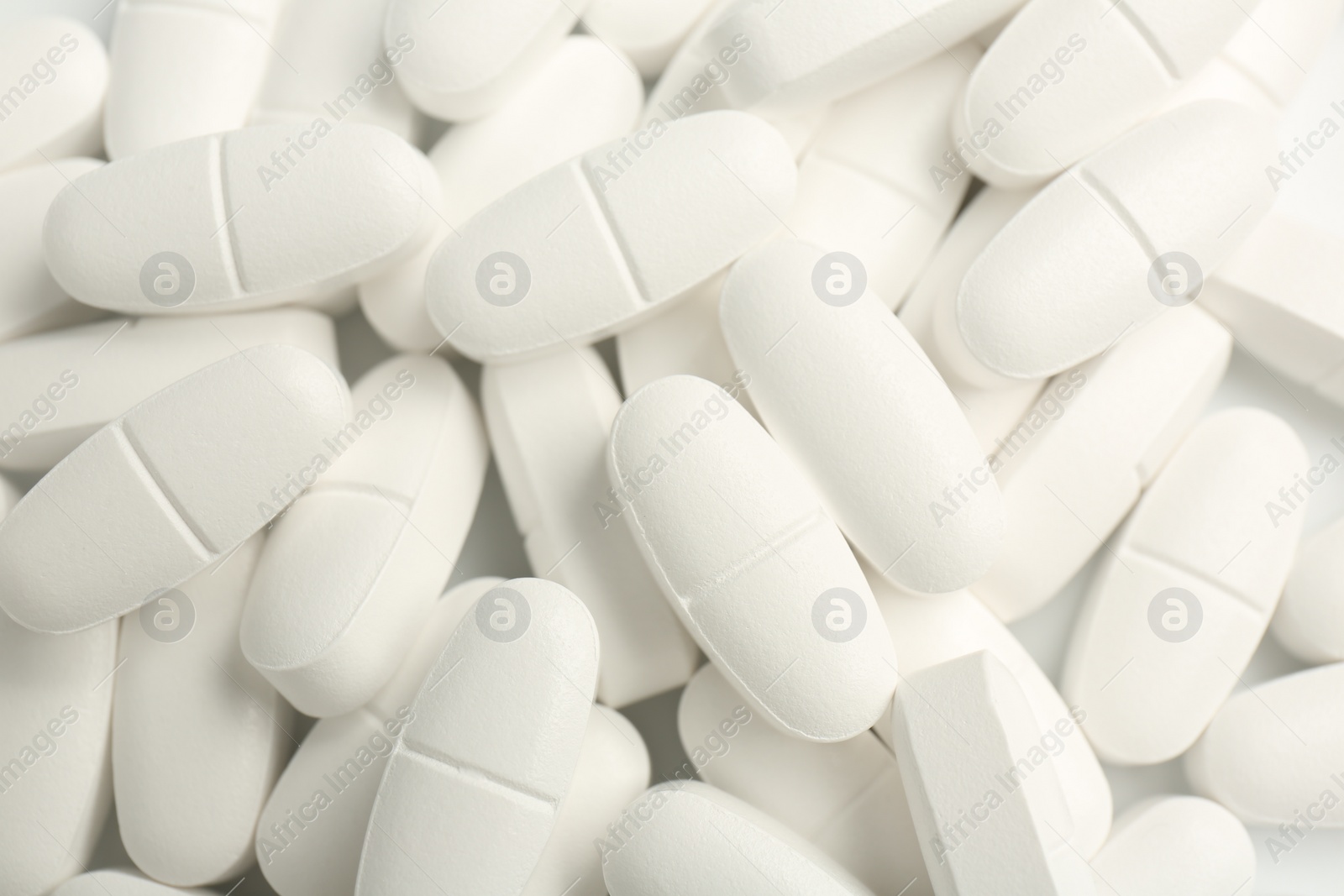 Photo of White vitamin capsules as background, top view