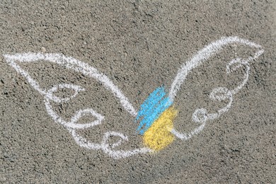 Angel with drawn with colorful chalks on asphalt outdoors, top view