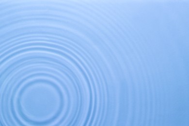 Image of Rippled surface of clear water on light blue background, top view