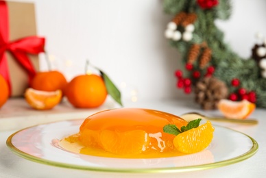 Photo of Plate with delicious tangerine jelly on white table