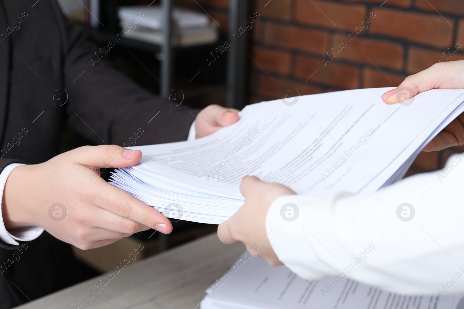 Photo of Woman giving many documents to man in office, closeup