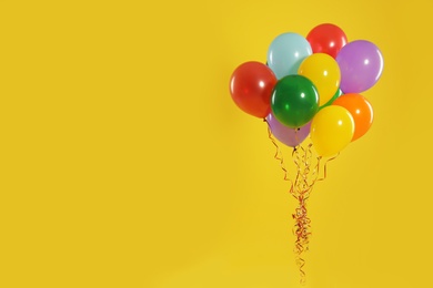 Bunch of bright balloons on color background, space for text. Celebration time