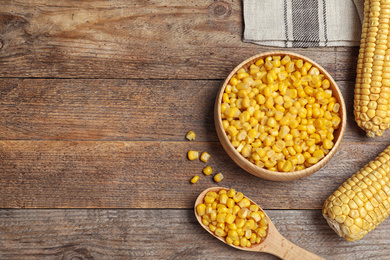 Photo of Delicious canned corn on wooden table, flat lay. Space for text