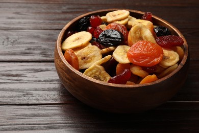 Mix of delicious dried fruits on wooden table, closeup. Space for text