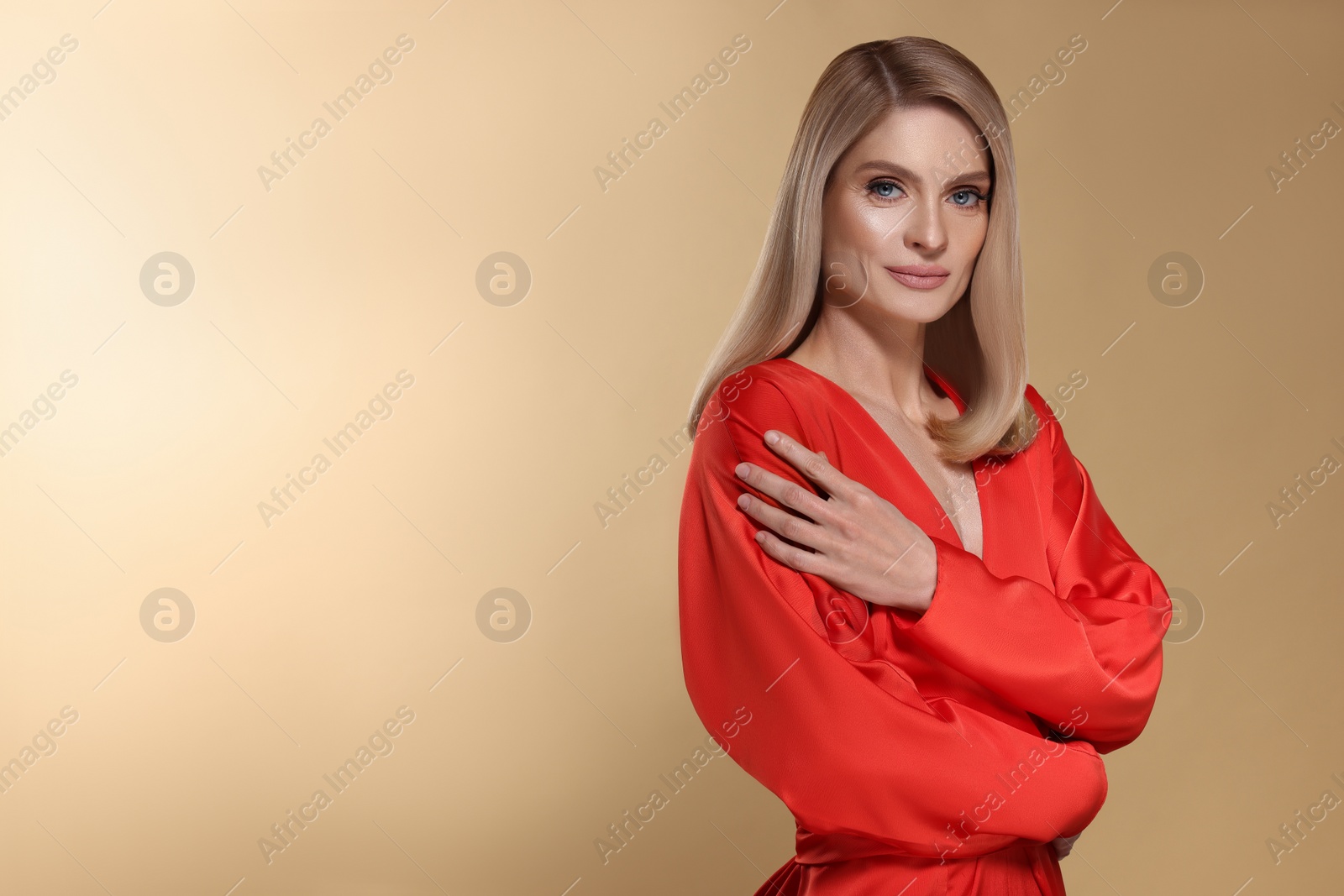 Image of Portrait of stylish attractive woman with blonde hair on dark beige background, space for text
