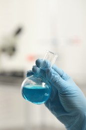 Photo of Scientist holding flask in laboratory, closeup view