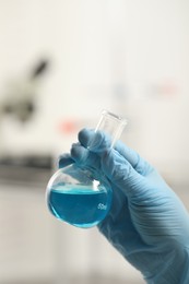 Scientist holding flask in laboratory, closeup view