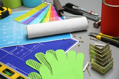 Photo of Set of decorator's tools and project drawings on table