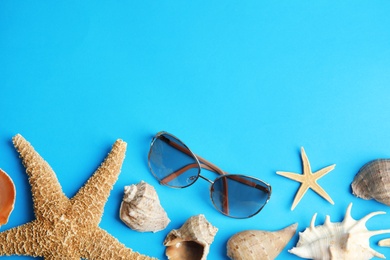 Flat lay composition with beach objects on blue background. Space for text