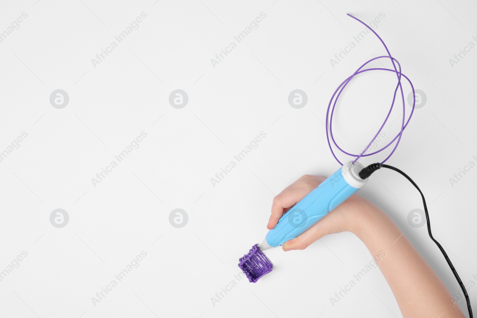 Photo of Boy drawing with stylish 3D pen on white background, top view. Space for text