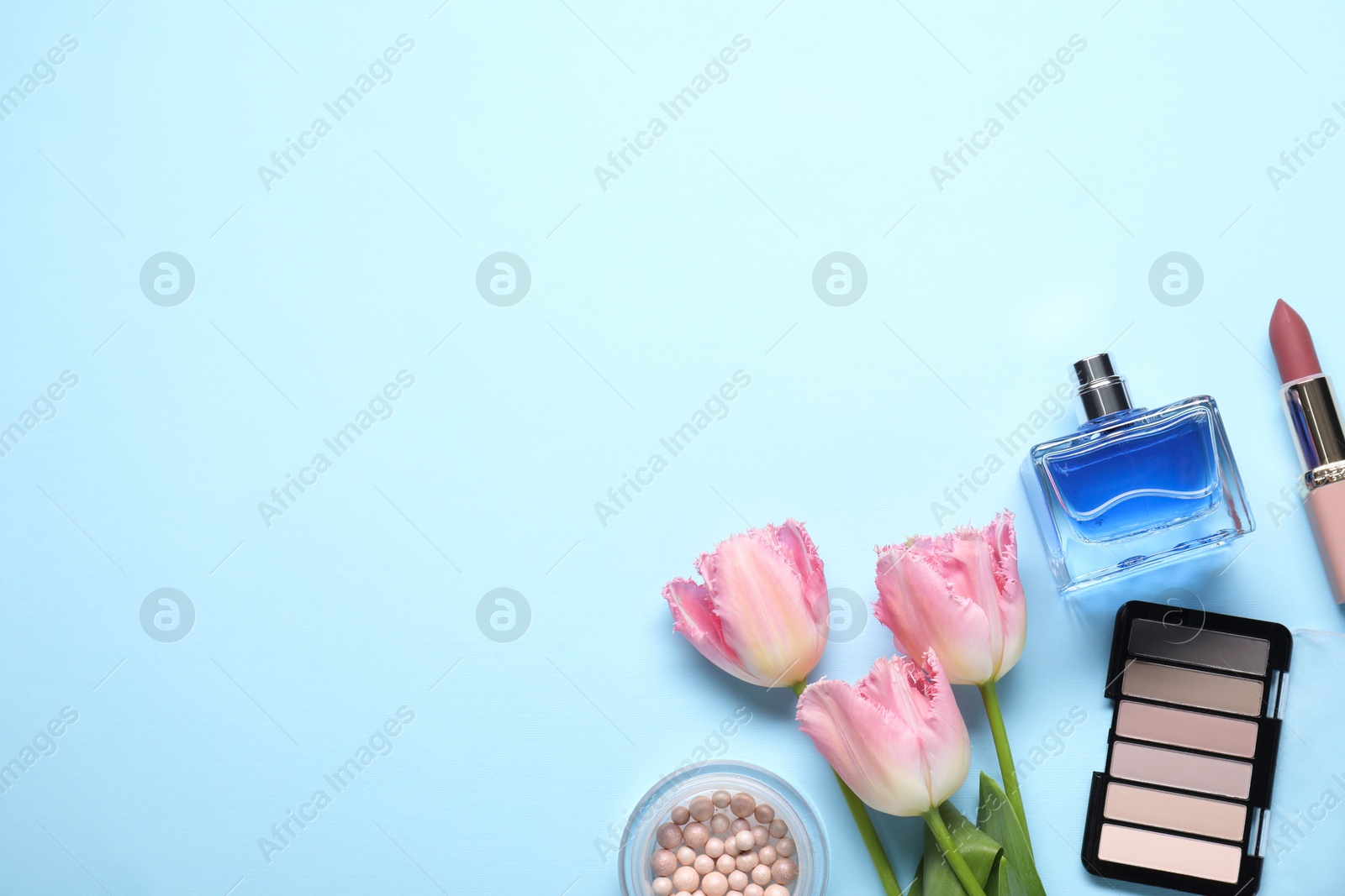 Photo of Flat lay composition with different makeup products and beautiful spring flowers on light blue background, space for text