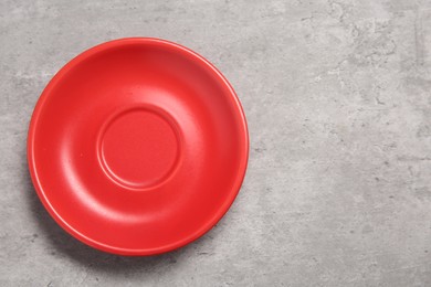 Photo of One red ceramic plate on light grey table, top view. Space for text