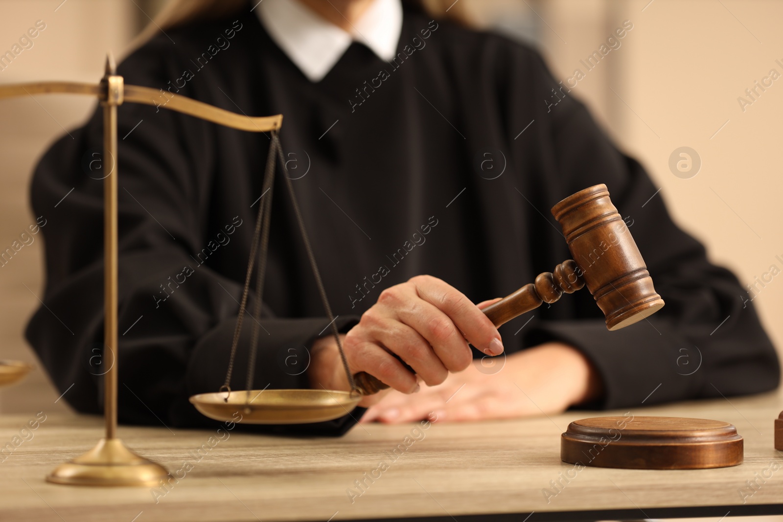 Photo of Judge striking mallet at wooden table indoors, closeup