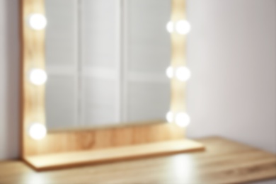 Table with mirror near white wall, closeup. Dressing room