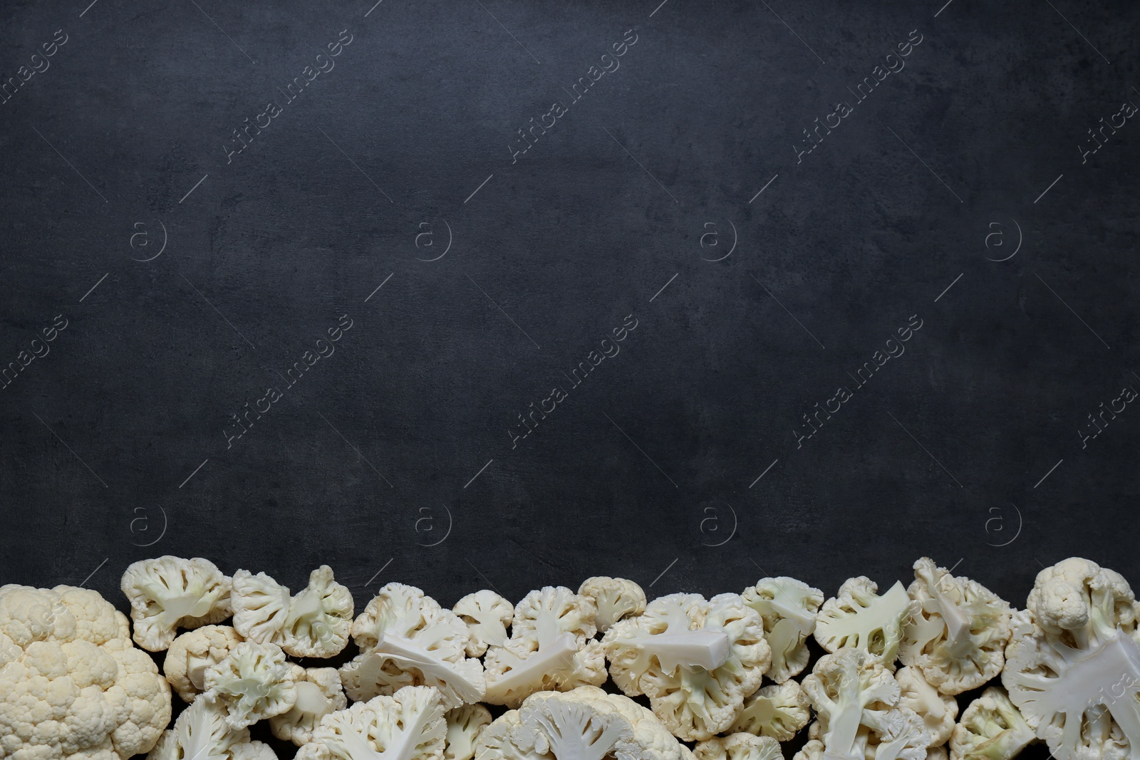 Photo of Cut fresh raw cauliflower on grey table, flat lay. Space for text