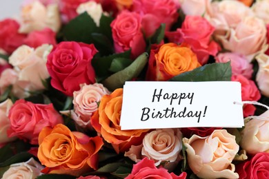 Image of Bouquet of beautiful roses with Happy Birthday card, closeup