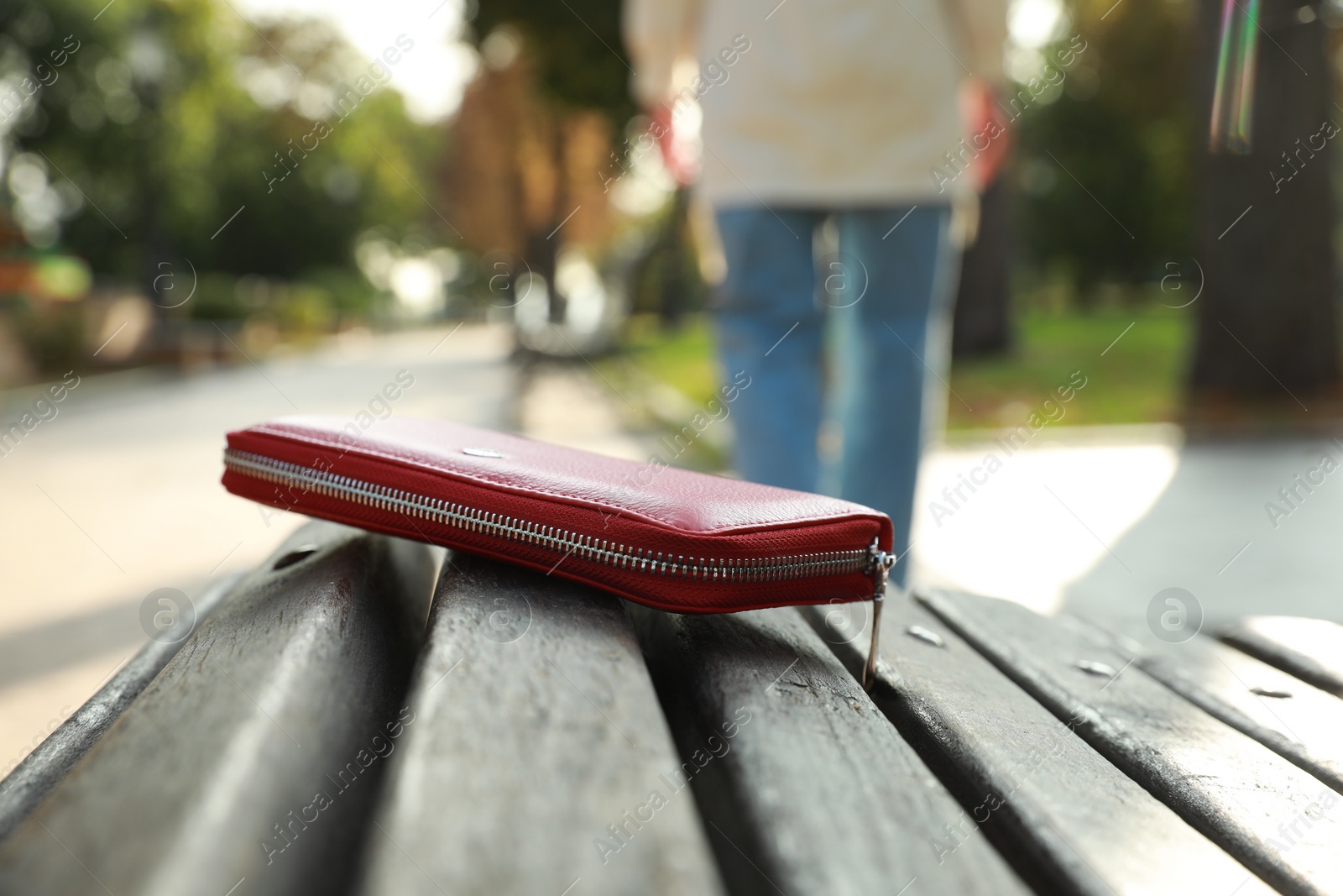 Photo of Woman lost her purse on wooden surface outdoors, selective focus. Space for text