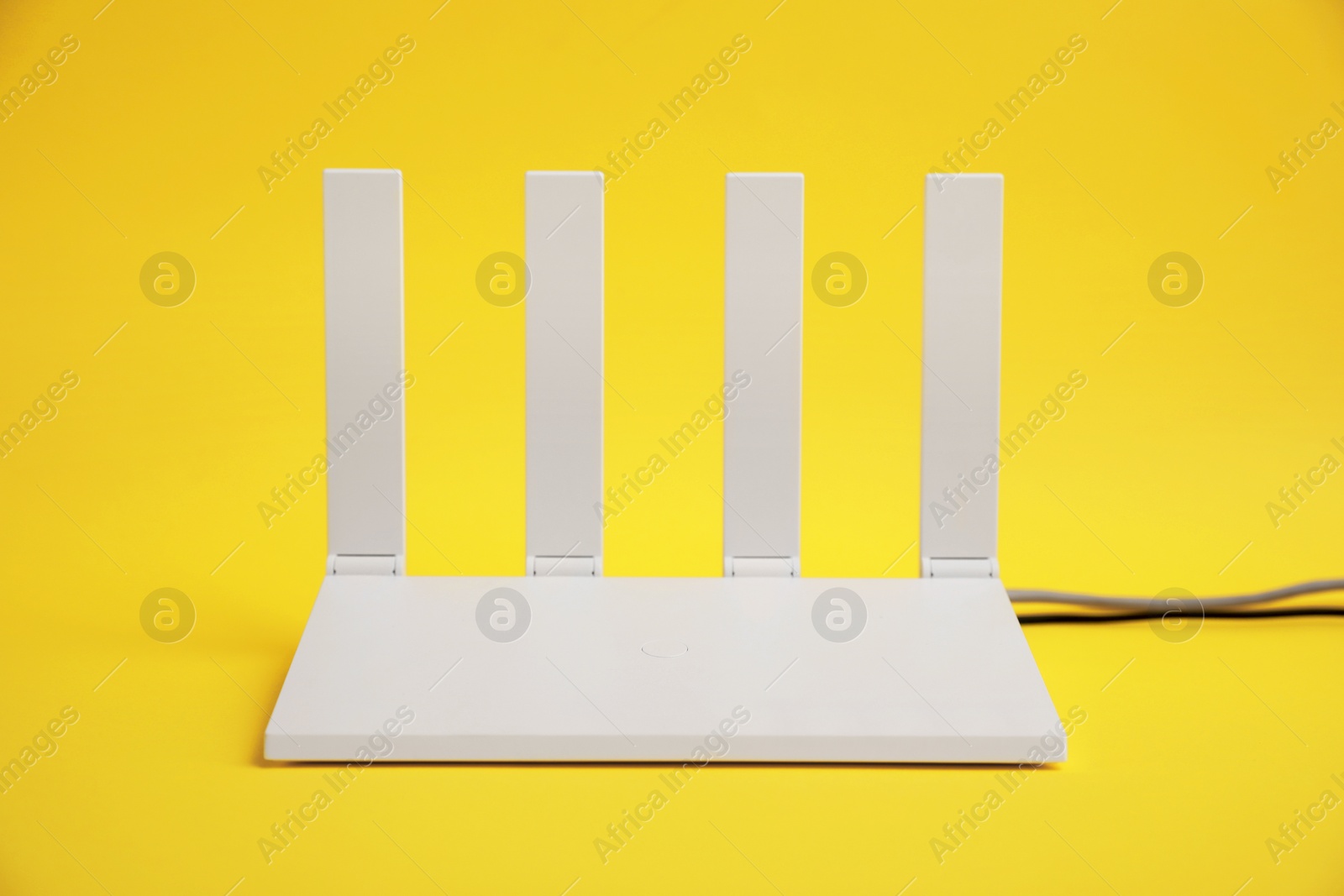 Photo of One modern Wi-Fi router on yellow background