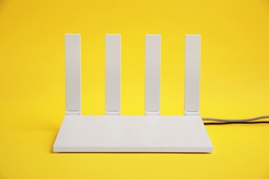 Photo of One modern Wi-Fi router on yellow background