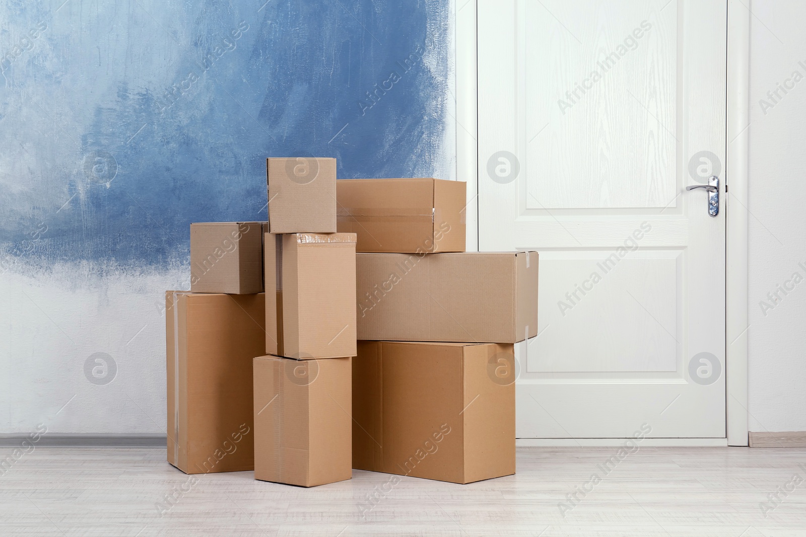 Photo of Cardboard boxes on floor near apartment entrance. Mockup for design