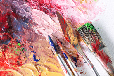Photo of Abstract colorful artwork and brushes, closeup view