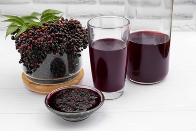 Elderberry drink and jam with Sambucus berries on white wooden table