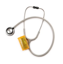 Stethoscope and container with pills isolated on white, top view. Medical tool