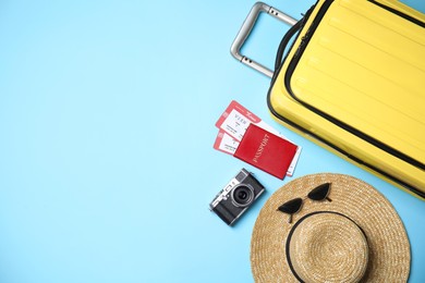 Photo of Flat lay composition with passport, tickets and travel items on light blue background. Space for text