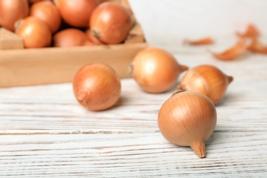 Fresh ripe onions on wooden table