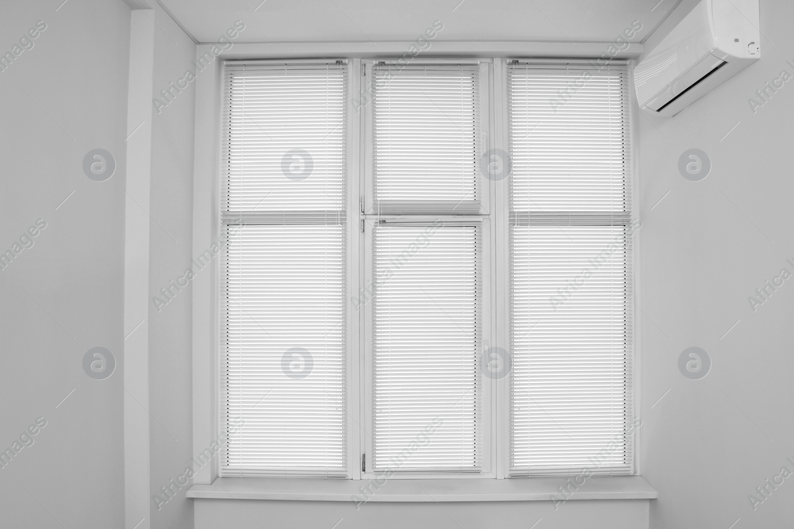 Photo of Stylish window with horizontal blinds in room