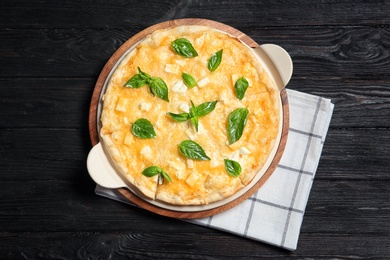 Fresh tasty homemade pizza on wooden background, top view