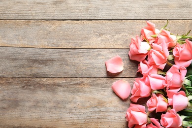 Photo of Beautiful roses on wooden table