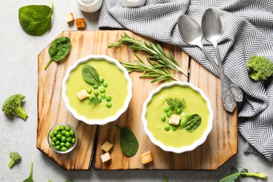 Photo of Fresh vegetable detox soup made of green peas and spinach served on table, flat lay