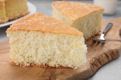 Pieces of tasty sponge cake on grey table, closeup