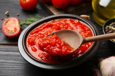 Photo of Eating homemade tomato sauce at black table, closeup