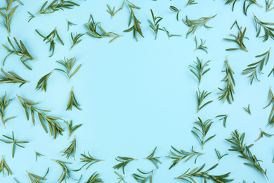 Frame made of fresh rosemary on light blue background, flat lay. Space for text