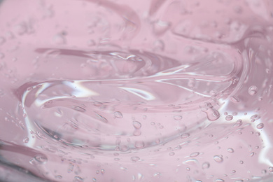 Photo of Pure transparent cosmetic gel on pink background, closeup