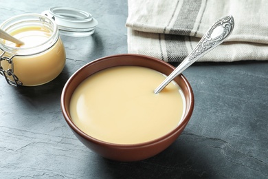 Bowl with condensed milk served on table. Dairy products