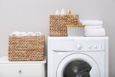 Photo of Laundry room with washing machine, detergents and clean towels. Tidying up method
