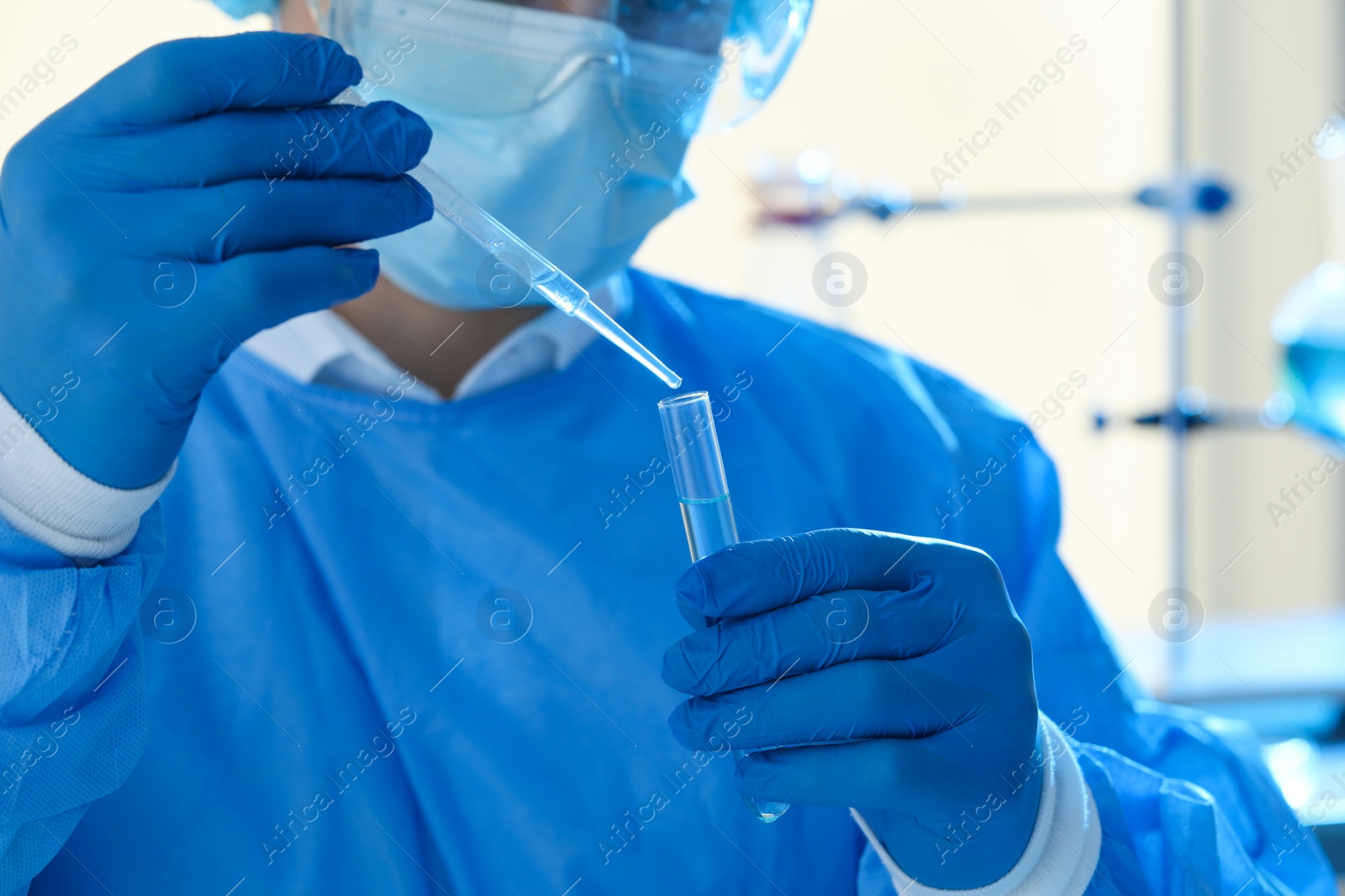 Photo of Scientist dripping sample into test tube in laboratory, closeup. Medical research