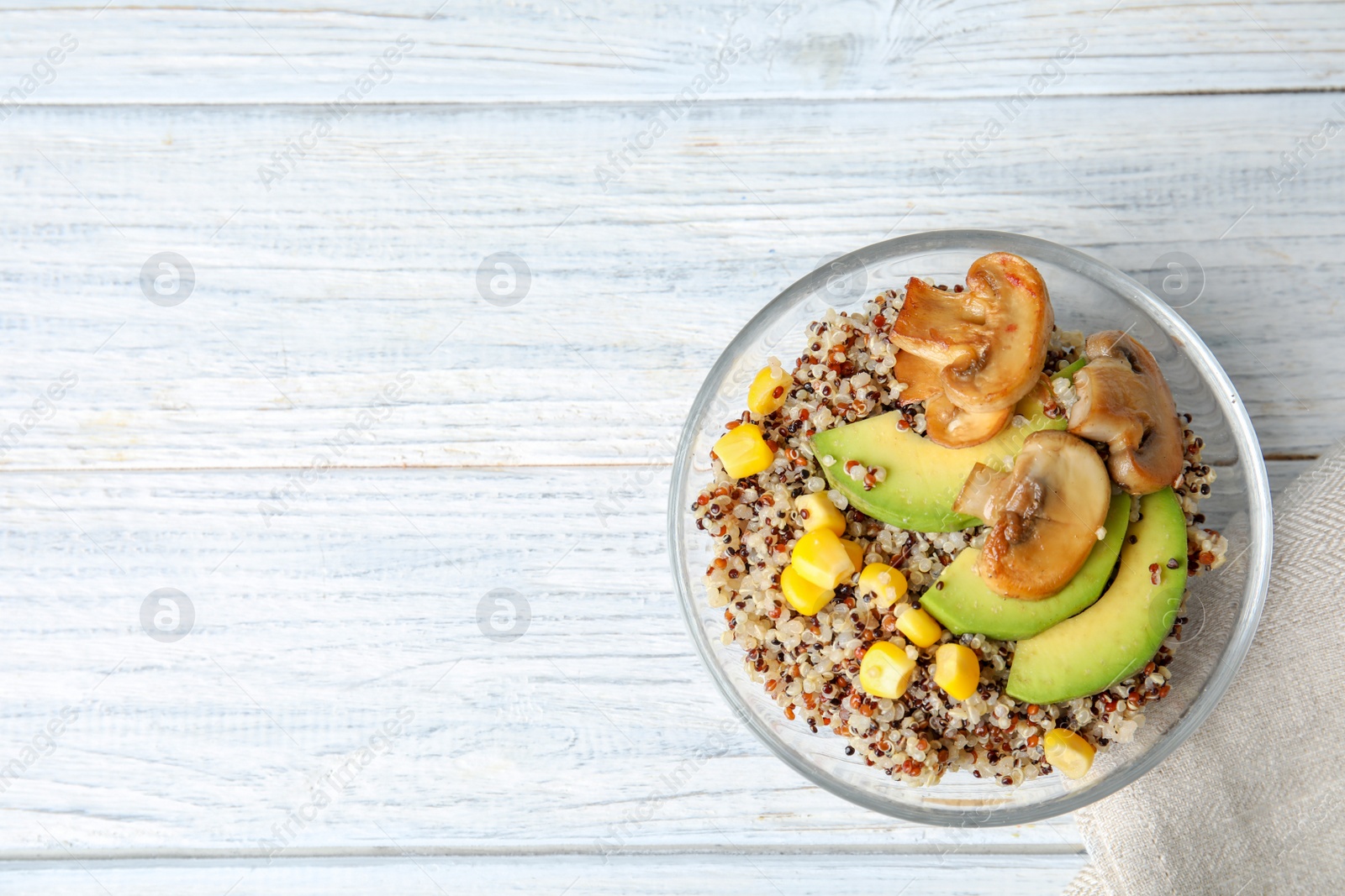 Photo of Healthy quinoa salad with vegetables in bowl on wooden table, top view. Space for text