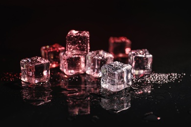 Pile of crystal clear ice cubes on black background