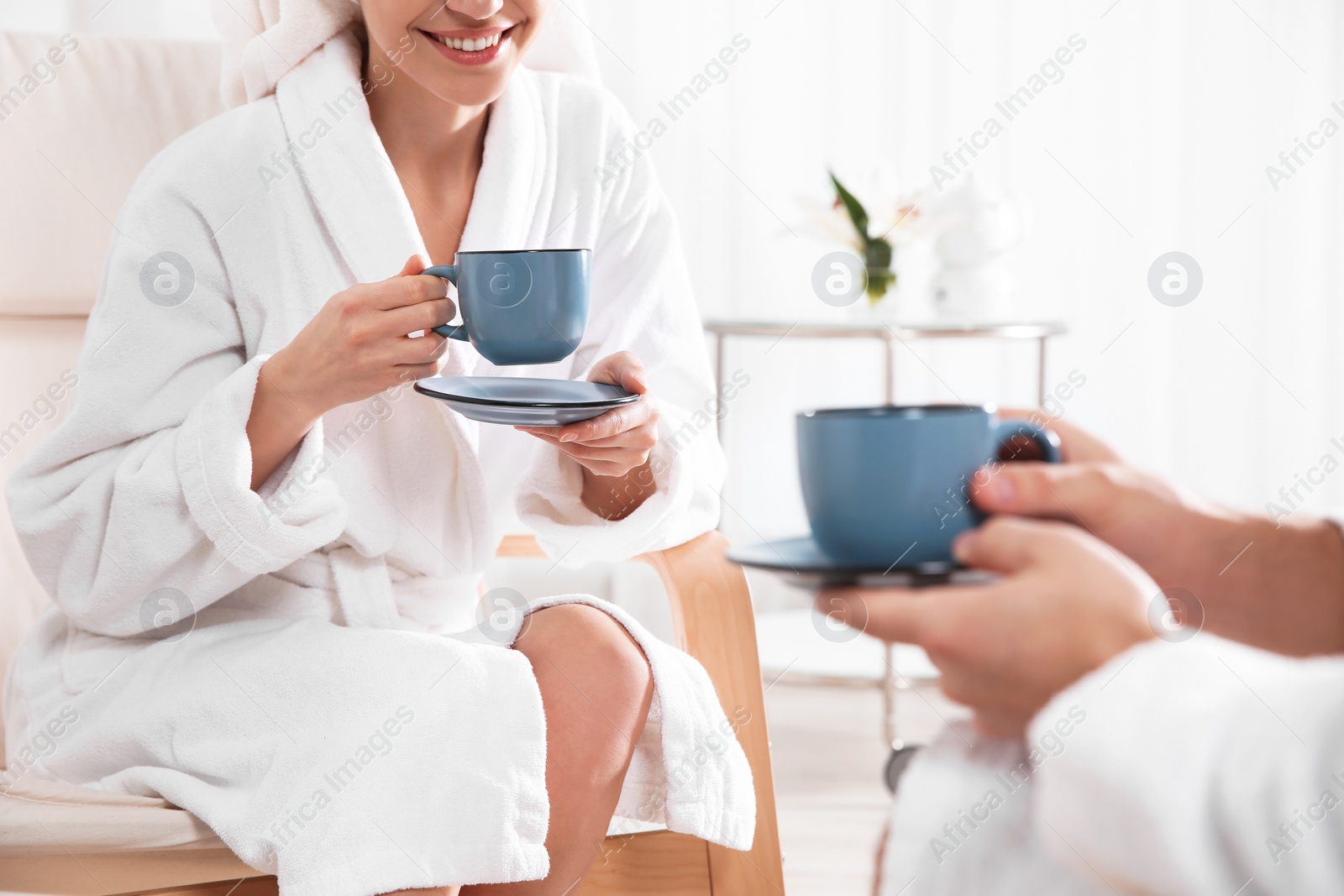 Photo of Romantic young couple drinking tea in spa salon, closeup